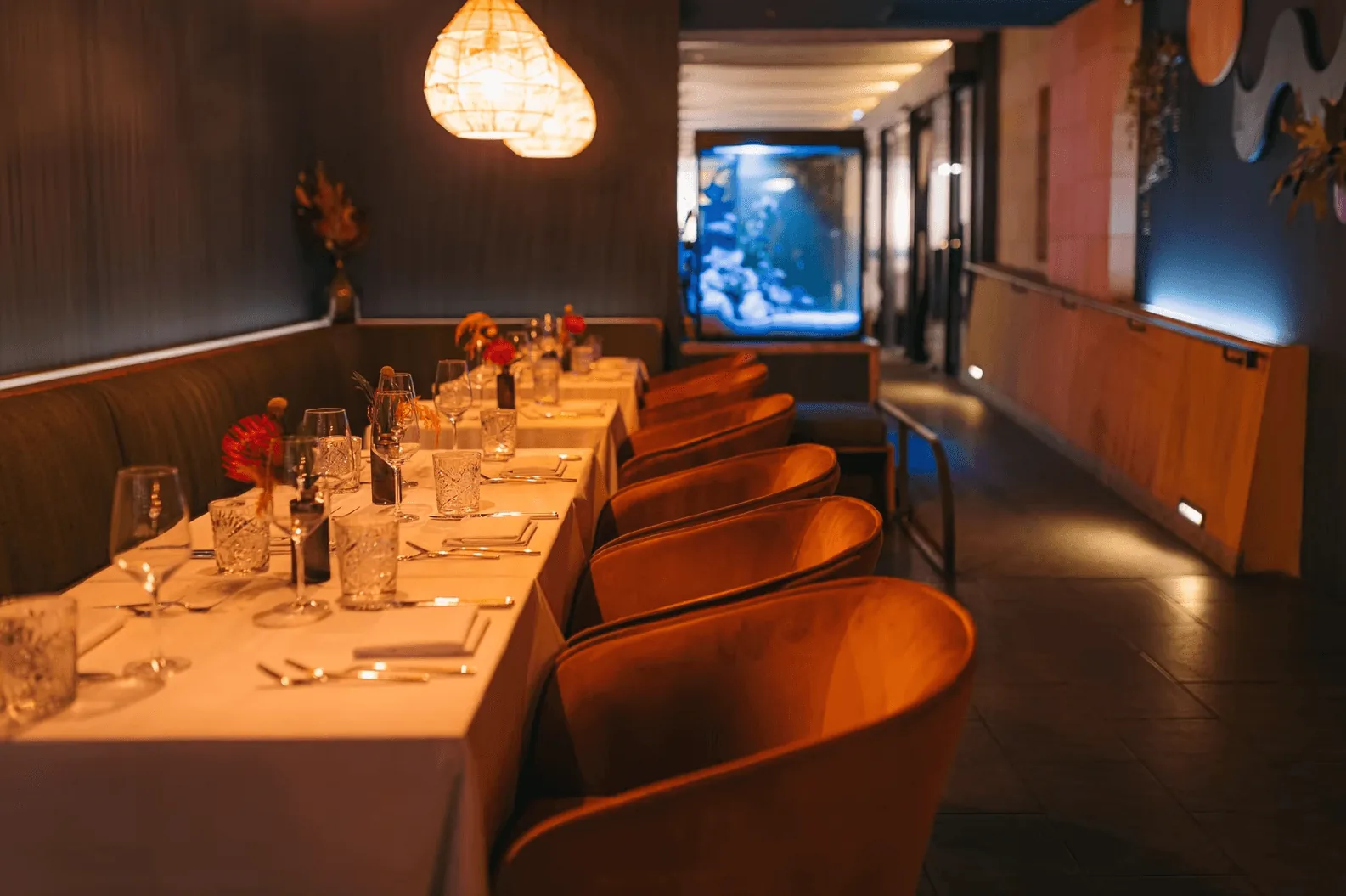 RIVO – Intimer Dinner-Bereich mit Aquarium und warmer Atmosphäre